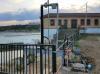 compuerta accionamiento oleohidráulico y poste con placa solar en presa de Milagro en el rio Aragon en Navarra